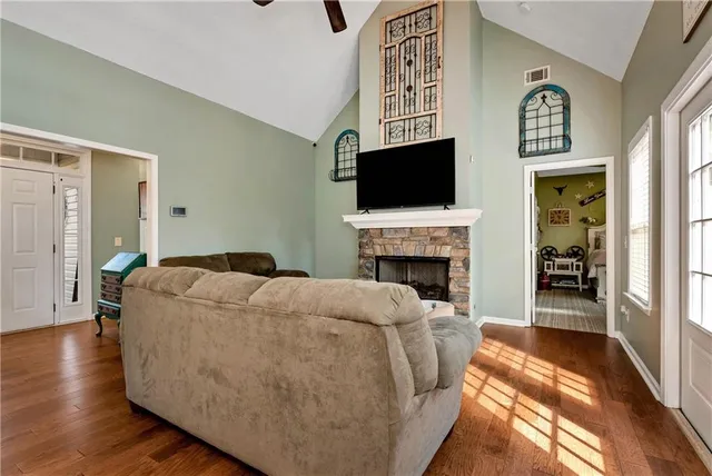 a living room with furniture and a black refrigerator