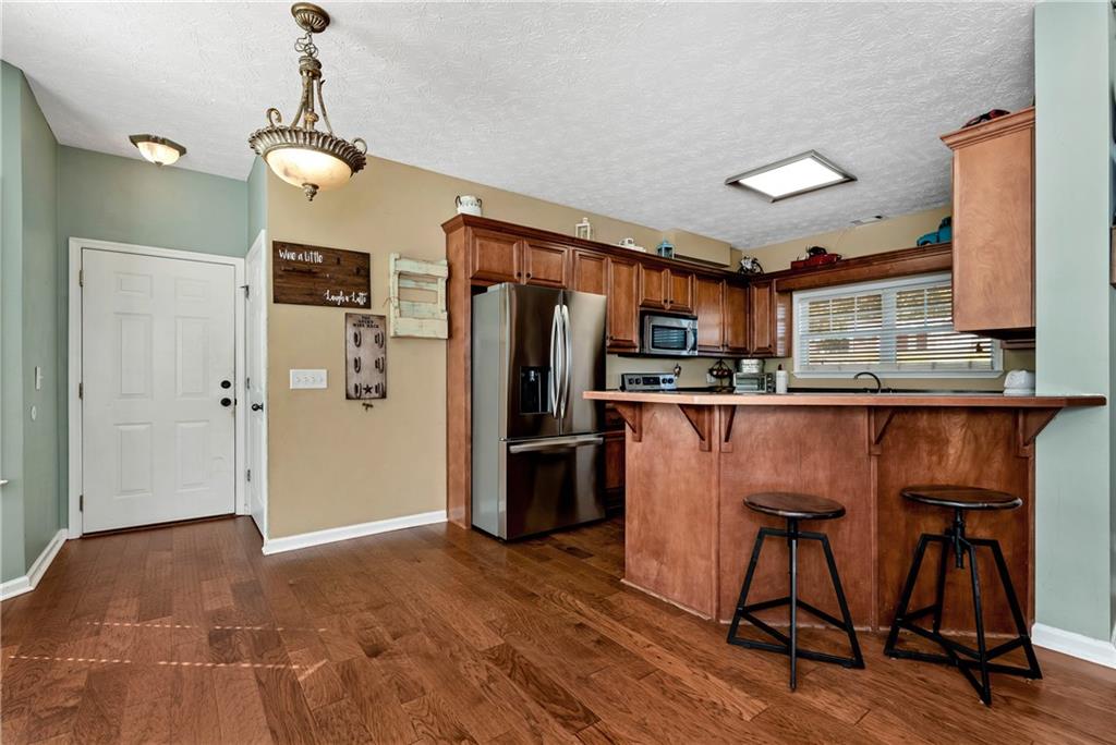 750 Rock Springs Road Lula, GA 30554 - Photo 14 of 72 a kitchen with stainless steel appliances granite countertop a refrigerator a stove and a sink with wooden floor