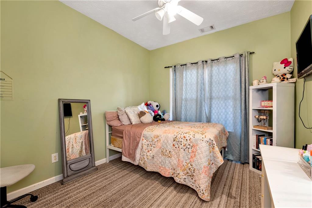 750 Rock Springs Road Lula, GA 30554 - Photo 32 of 72 a bedroom with a bed and a chandelier