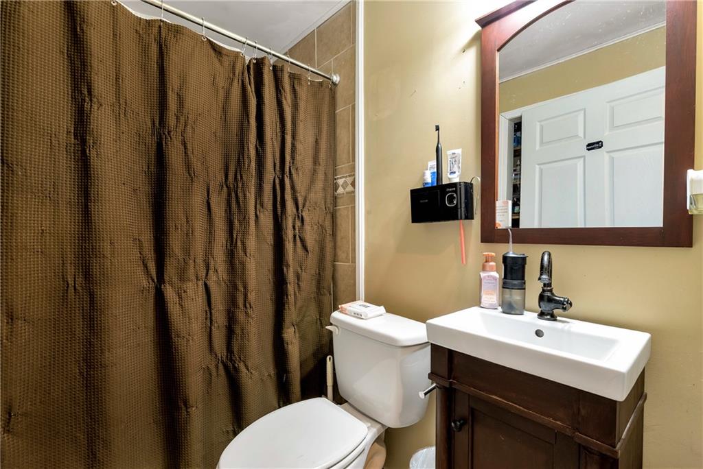 750 Rock Springs Road Lula, GA 30554 - Photo 45 of 72 a bathroom with a sink a toilet a mirror and shower curtain
