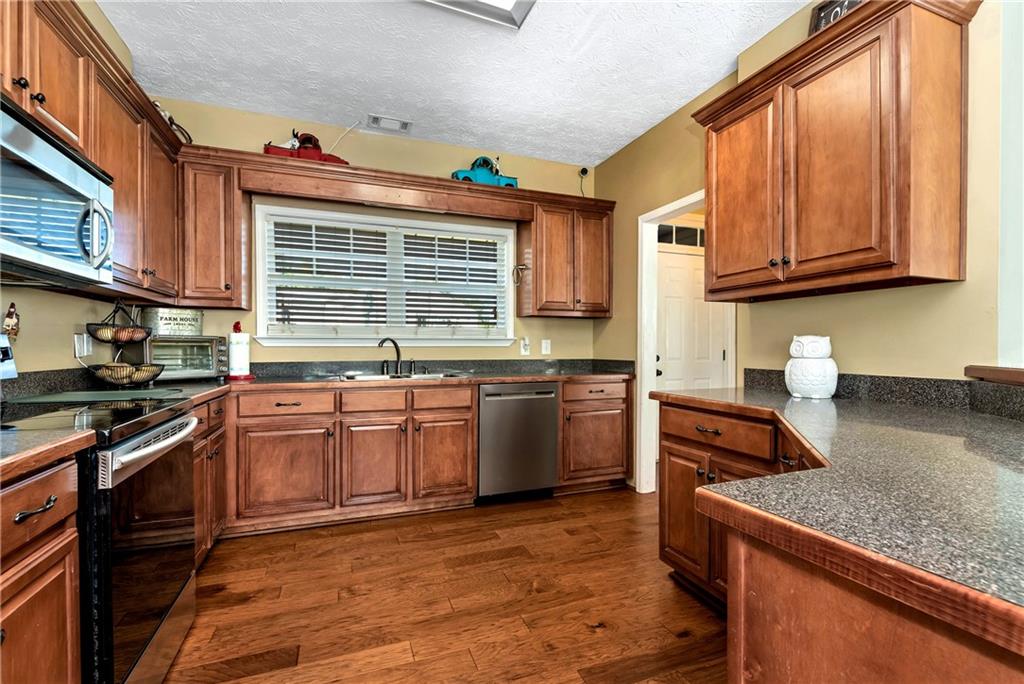 750 Rock Springs Road Lula, GA 30554 - Photo 10 of 72 a kitchen with stainless steel appliances granite countertop a stove a sink and a microwave