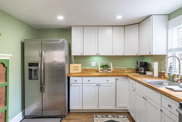 a kitchen with a sink a refrigerator and cabinets