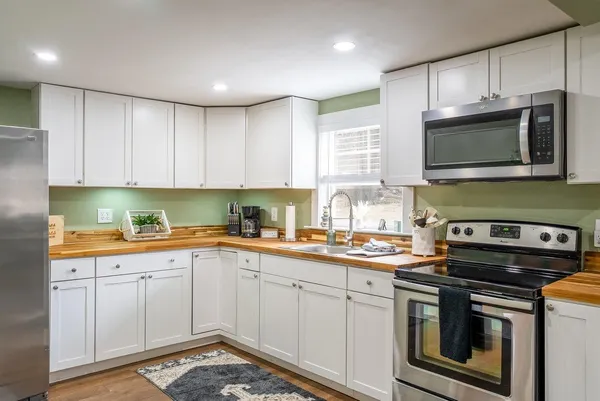 a kitchen with stainless steel appliances granite countertop a sink stove and microwave