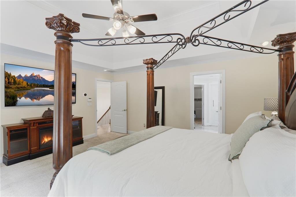 67 Pointer Lane Braselton, GA 30517 - Photo 51 of 74 a bedroom with a bed a flat screen tv and a chandelier