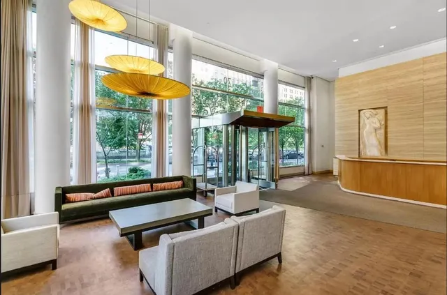 a living room with fireplace furniture and floor to ceiling window