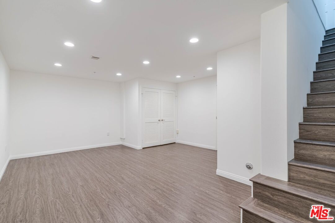 5521 Kester Avenue, Unit 7 Sherman Oaks, CA 91411 - Photo 14 of 45 a view of an empty room with wooden floor and stairs