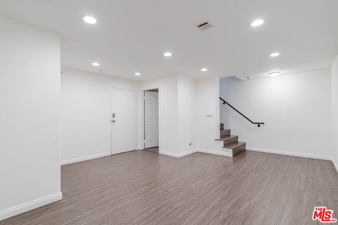 5521 Kester Avenue, Unit 7 Sherman Oaks, CA 91411 - Photo 15 of 45 an empty room with wooden floor and a ceiling fan