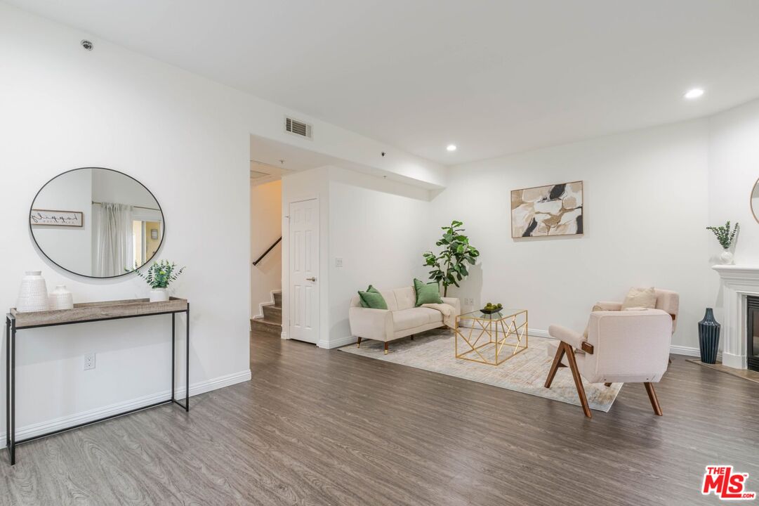 5521 Kester Avenue, Unit 7 Sherman Oaks, CA 91411 - Photo 2 of 45 a living room with furniture a mirror wooden floor and a large window