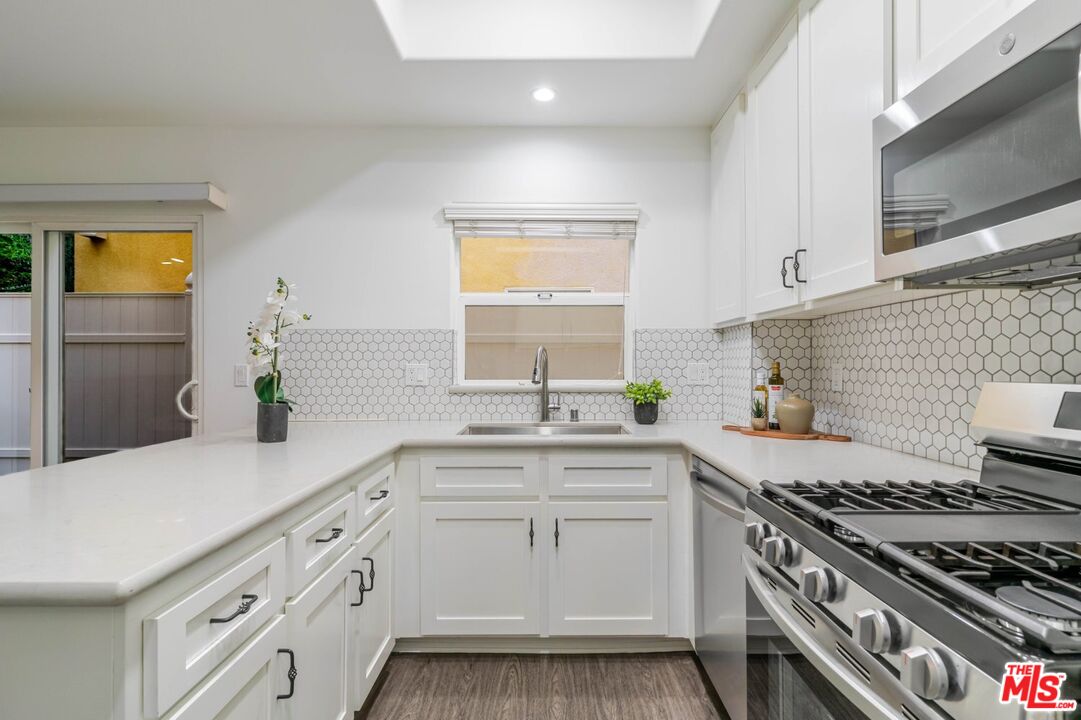 5521 Kester Avenue, Unit 7 Sherman Oaks, CA 91411 - Photo 9 of 45 a kitchen with white cabinets and appliances