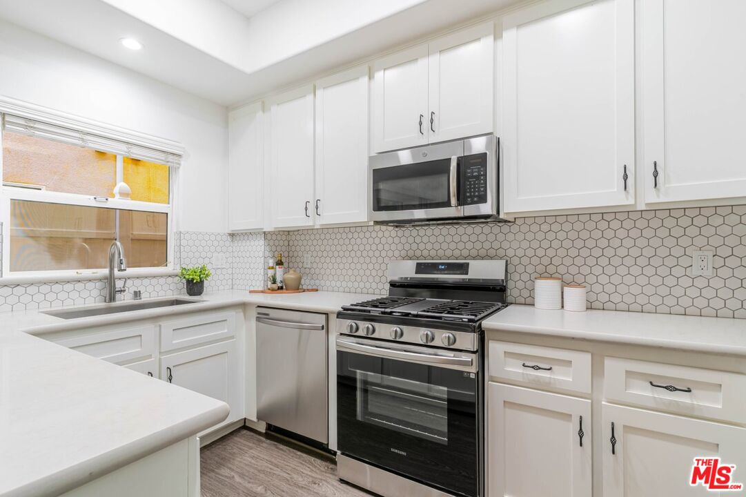 5521 Kester Avenue, Unit 7 Sherman Oaks, CA 91411 - Photo 10 of 45 a kitchen with cabinets stainless steel appliances a sink and a window