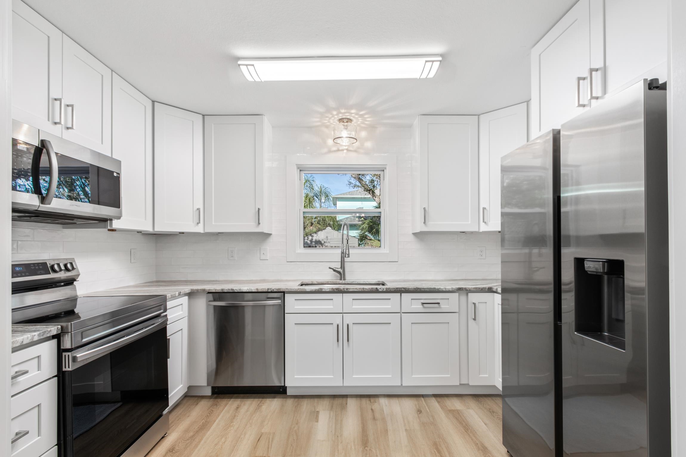 112 2nd Street, Unit A St. Augustine, FL 32080 - Photo 12 of 48 a kitchen with white cabinets stainless steel appliances and a sink
