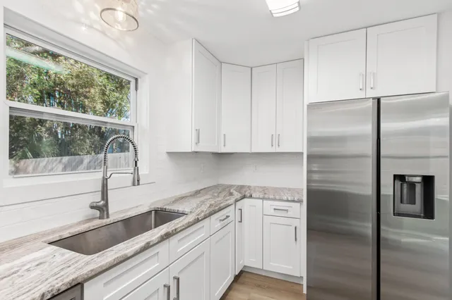 a kitchen with a refrigerator sink and cabinets