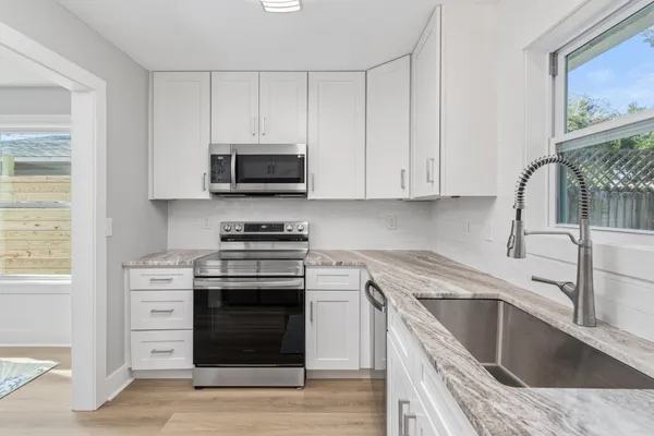 a kitchen with stainless steel appliances granite countertop a stove and a sink