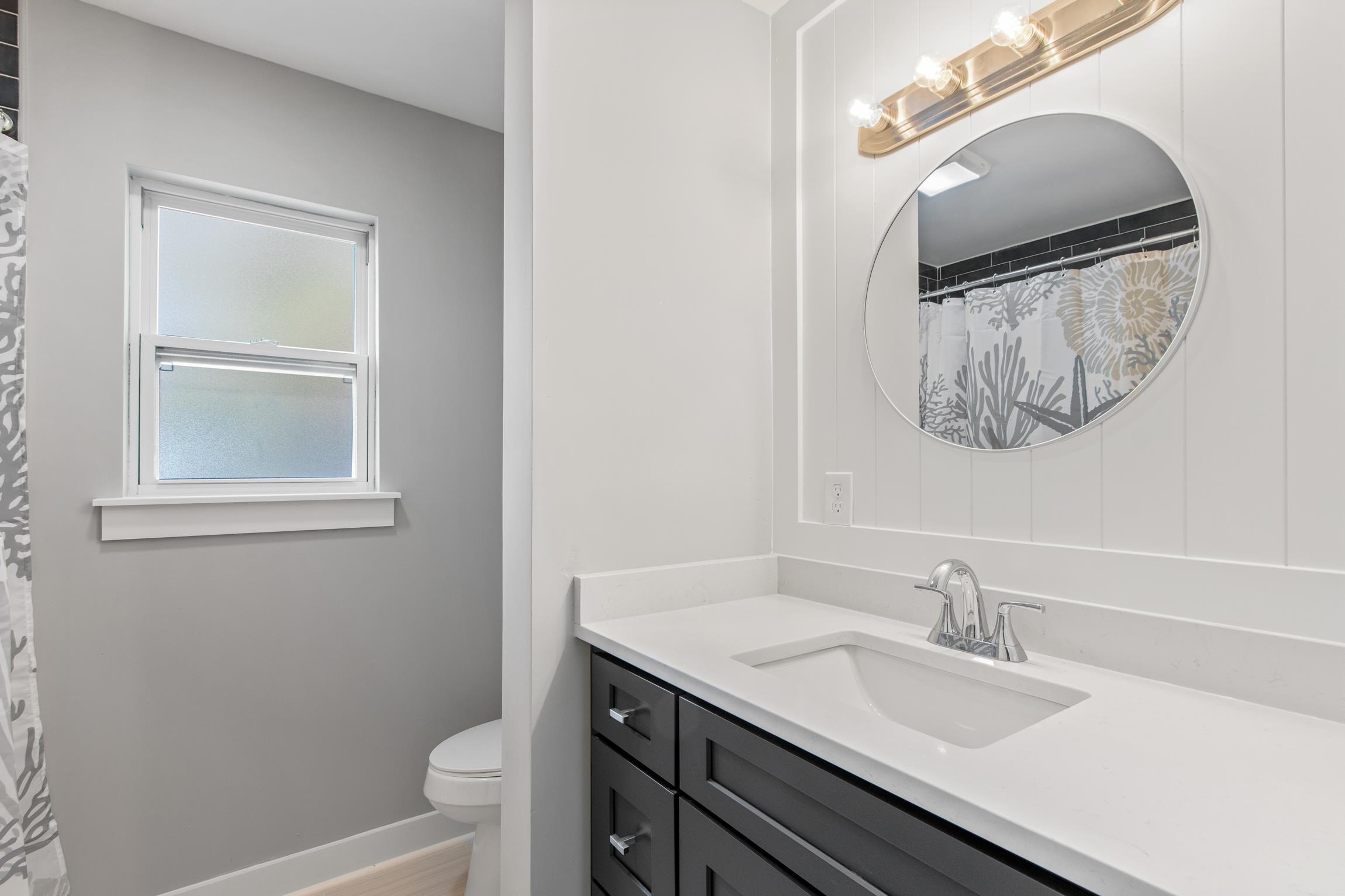112 2nd Street, Unit A St. Augustine, FL 32080 - Photo 28 of 48 a bathroom with a granite countertop sink vanity mirror and toilet