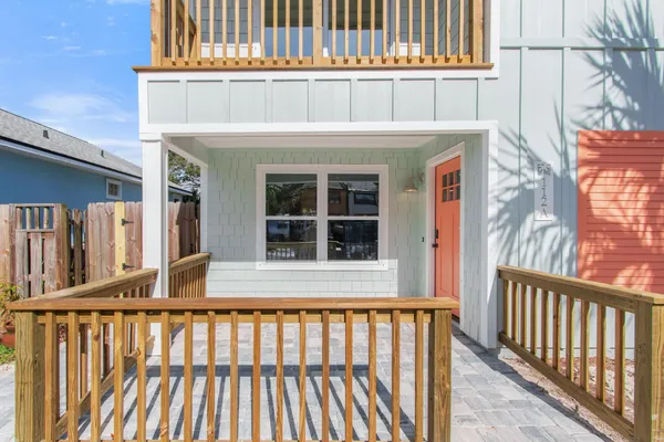 a view of a house with a small yard and wooden fence