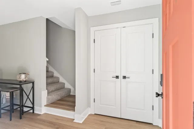 a view of a hallway with wooden floor and entryway