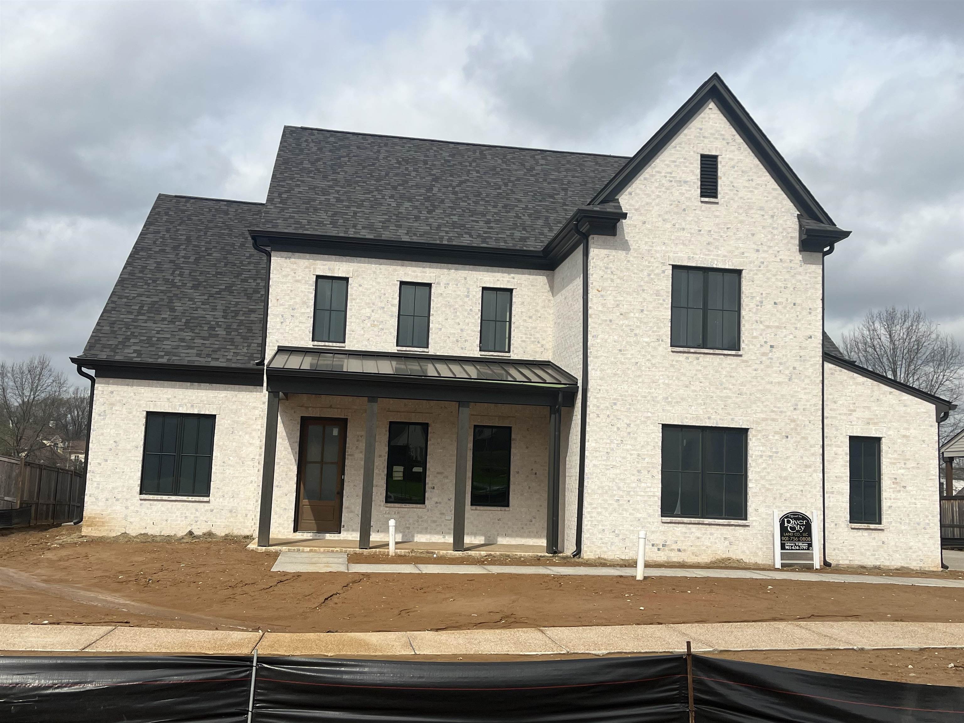 Modern inspired farmhouse with a porch, brick siding, a standing seam roof, and roof with shingles