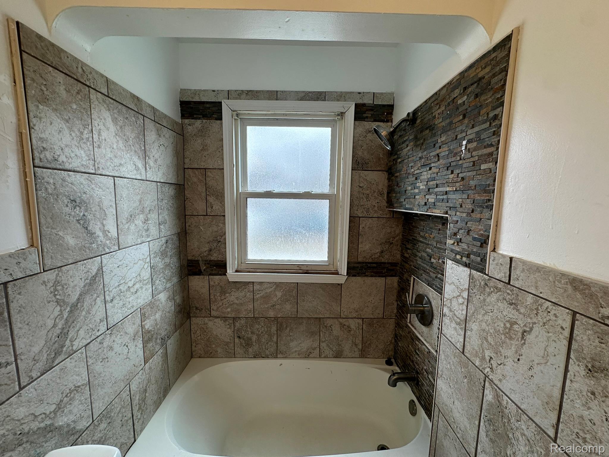 15759 Evergreen Road Detroit, MI 48223 - Photo 18 of 25 Full bathroom featuring bathtub / shower combination, a wainscoted wall, and tile walls