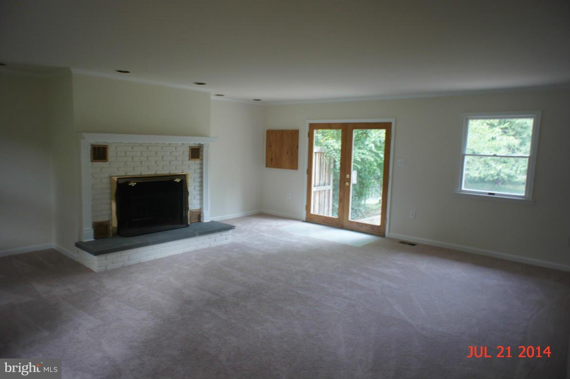 1821 Hatfield Road Huntingtown, MD 20639 - Photo 7 of 18 an empty room with windows and fireplace
