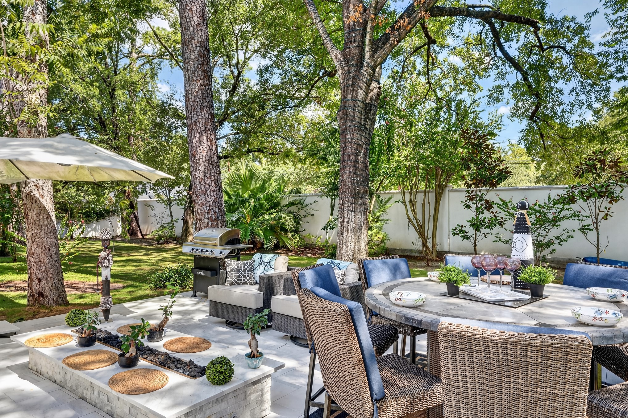 335 Voss Road Houston, TX 77024 - Photo 37 of 50 Elegant outdoor living area surrounded by mature trees and lush landscaping.