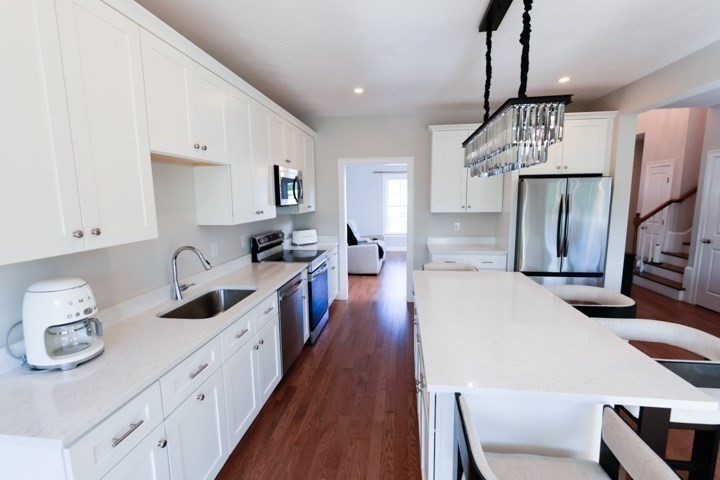 31 Lilac Avenue Bellingham, MA 02019 - Photo 3 of 40 a kitchen with sink refrigerator and wooden floor