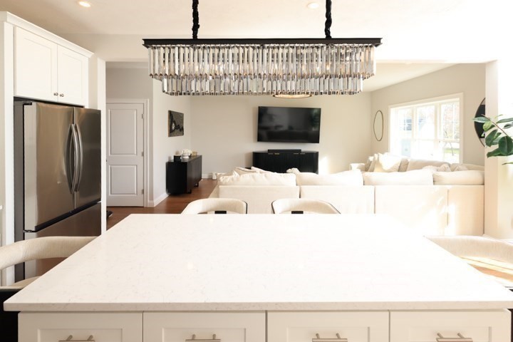 31 Lilac Avenue Bellingham, MA 02019 - Photo 9 of 40 a living room with furniture a flat screen tv and a refrigerator
