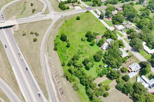 an aerial view of a house with a yard and large trees