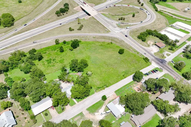 an aerial view of a residential houses with yard