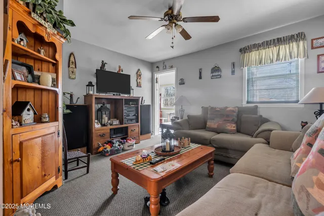 a living room with furniture and ceiling fan