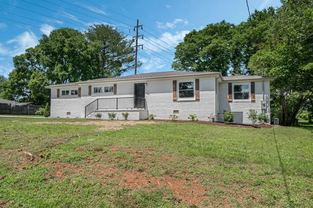 a view of a house with backyard and a garden