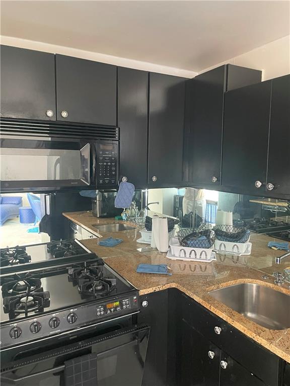 620 Peachtree Street Northeast, Unit 901 Atlanta, GA 30308 - Photo 15 of 19 a kitchen with granite countertop a sink a stove and wooden cabinets
