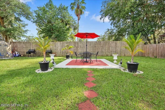a view of a backyard with table and chairs