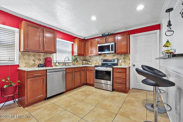 a kitchen with stainless steel appliances granite countertop a stove a sink a microwave and a refrigerator