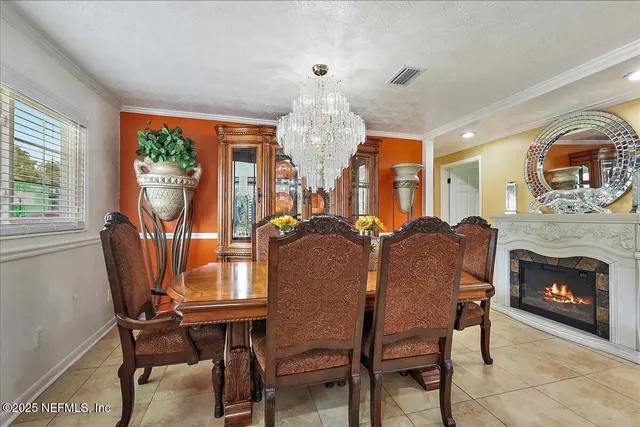 a living room with furniture a chandelier and a fireplace