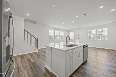 a kitchen with counter top space and wooden floor