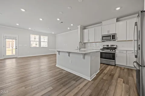 a kitchen with stainless steel appliances granite countertop a stove a sink and a refrigerator
