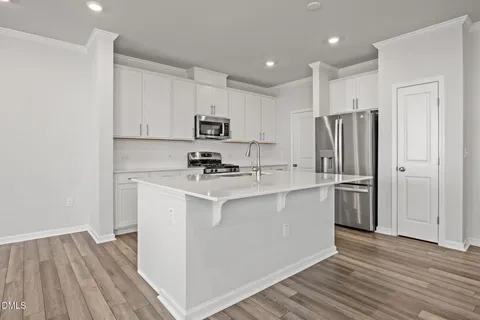a kitchen with stainless steel appliances a refrigerator sink and microwave