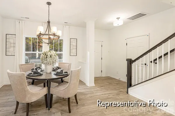 a dining room with furniture a chandelier and wooden floor