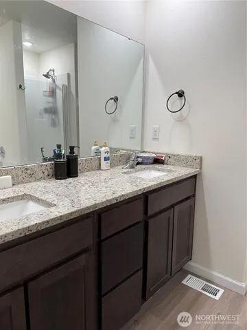 a bathroom with a granite countertop sink and a mirror