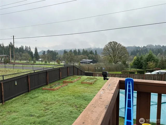 a view of a lake with a yard and large trees