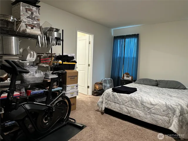 a bedroom with bed a mirror and dresser