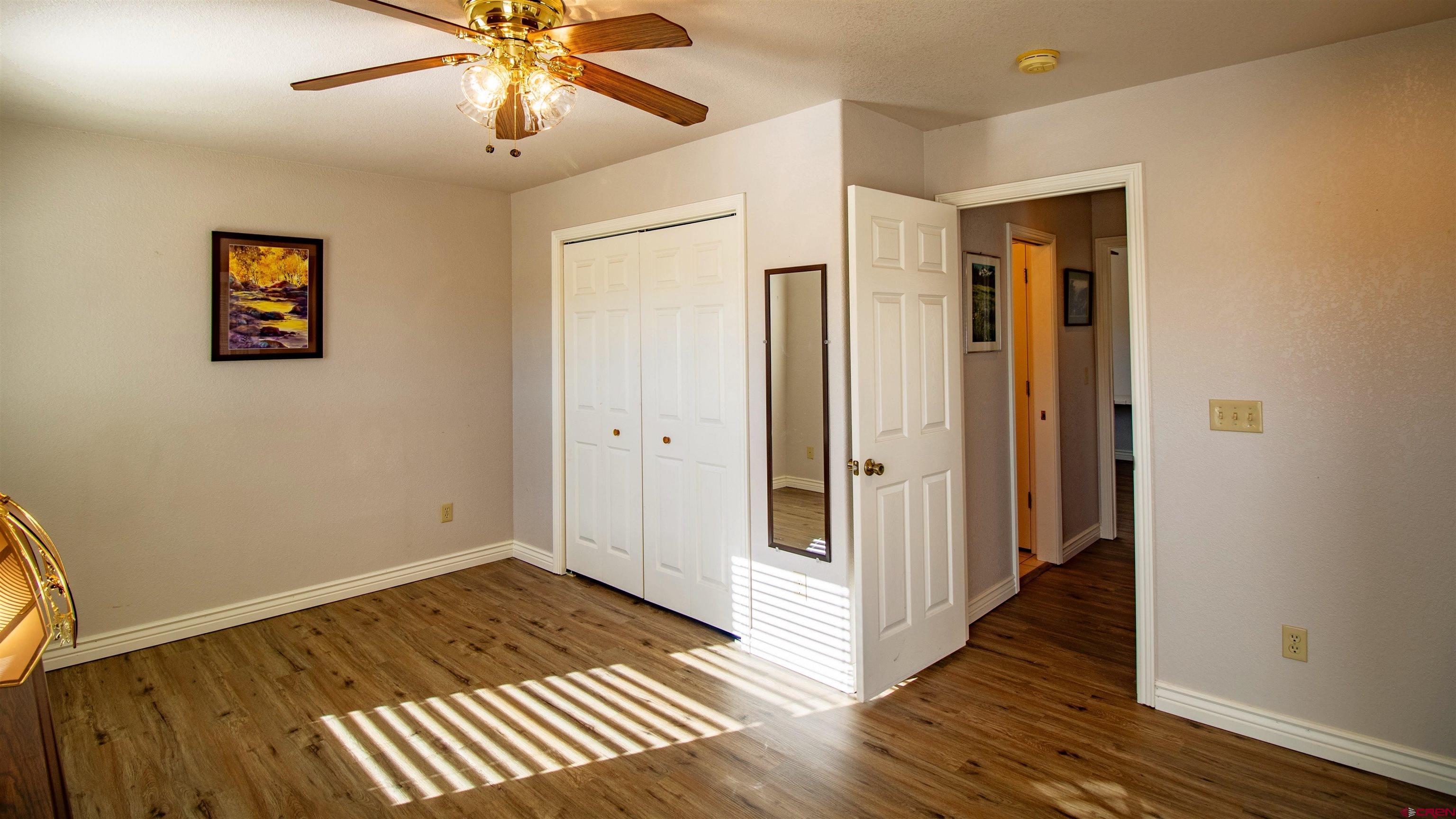 18641 2375th Road Cedaredge, CO 81413 - Photo 13 of 35 an empty room with wooden floor closet and a ceiling fan