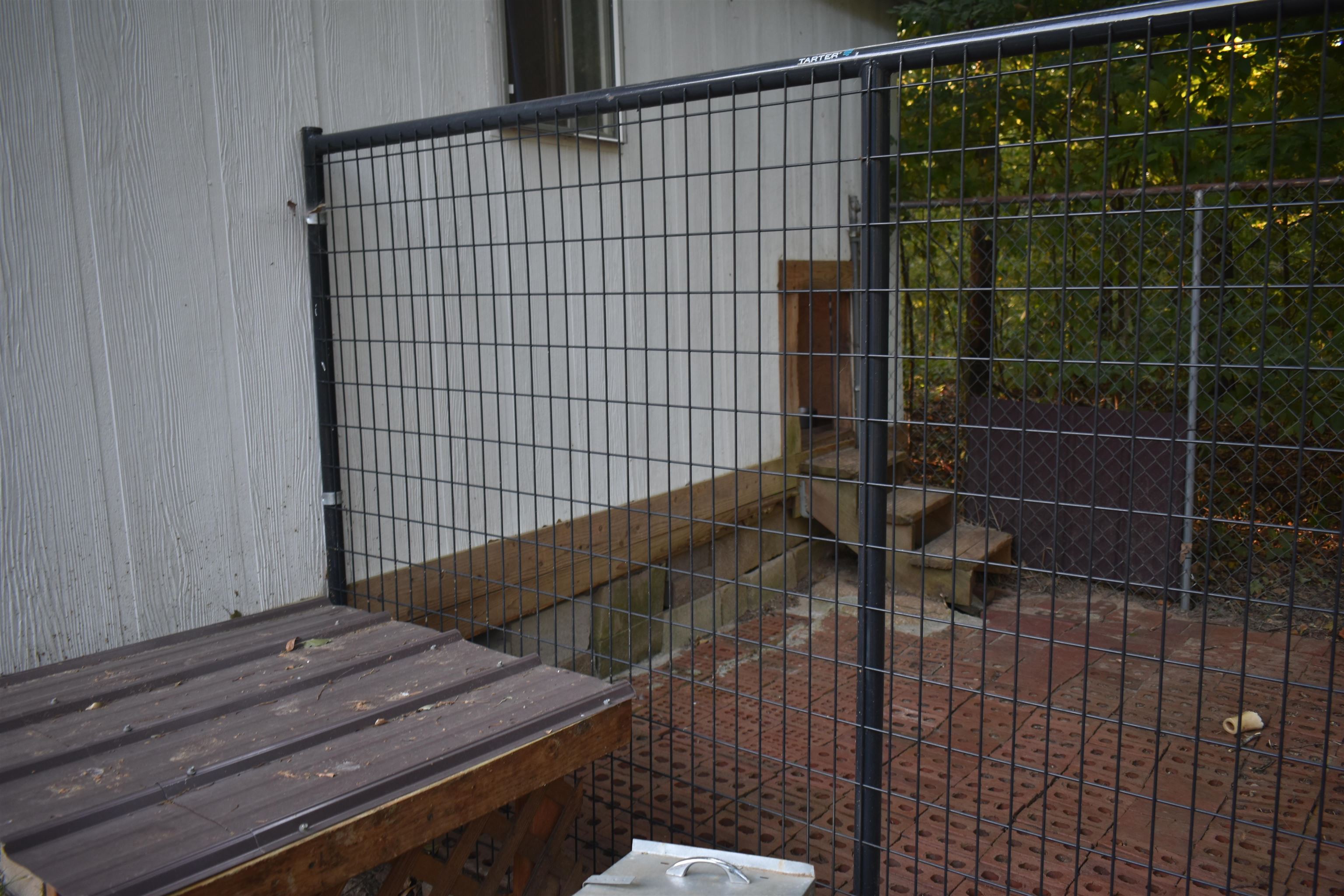 82 Ester Lane Ramer, TN 38367 - Photo 39 of 40 Exterior wall with horizontal siding, metal grate fencing, brick paver ground surface, and wooden steps