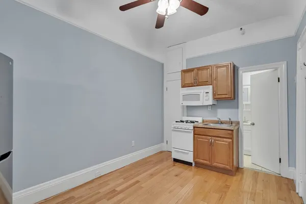 a kitchen with stainless steel appliances granite countertop a sink and a wooden floor