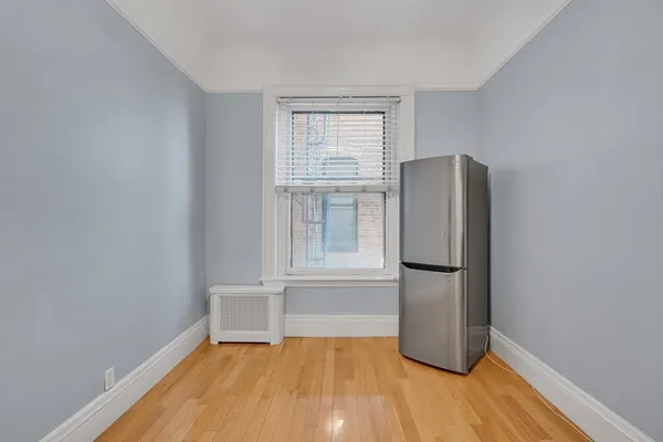 a view of a kitchen with wooden floor and a window