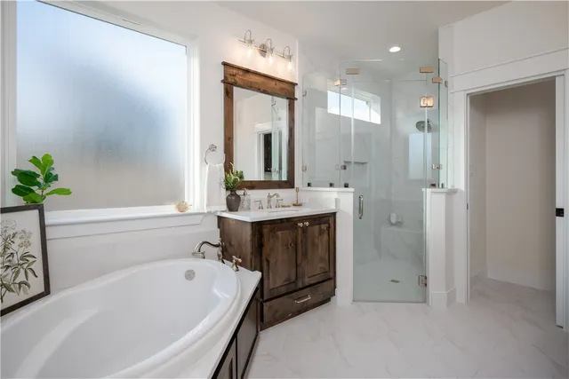 a bathroom with a tub a sink shower and a mirror