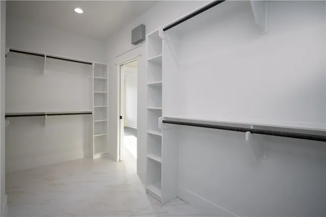 a view of walk in closet with empty racks