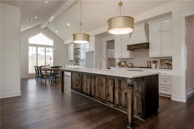 a kitchen with stainless steel appliances a table chairs refrigerator and cabinets
