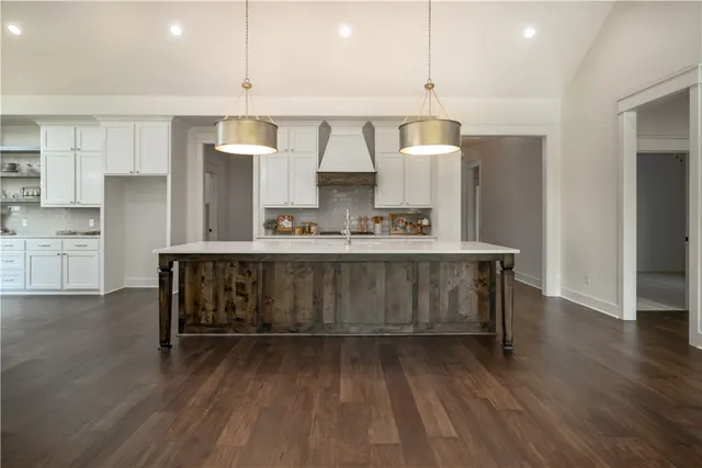 a kitchen with kitchen island a sink stainless steel appliances and cabinets