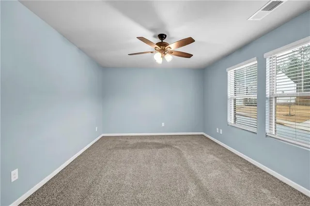 a view of a room with a ceiling fan and a window